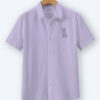 Lavender oversized cotton shirt with geometric fox embroidery on the chest, displayed on a wooden hanger.