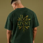 Model wearing a green acid-wash oversized T-shirt with LIVNT botanical logo on the back, unisex streetwear style.