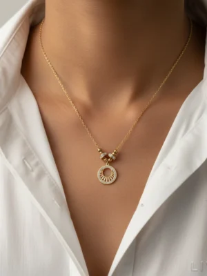 A gold circular halo pendant necklace with crystal accents, symbolizing radiance and renewal, styled with a white shirt