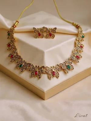 LIVNT's Butterfly Gem Set with necklace and earrings in an antique gold finish, displayed on a satin box.