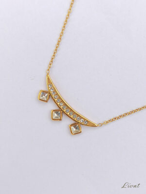Angled view of LIVNT Celestial Curve Necklace highlighting crystal-set arc and chain connection on clean white backdrop