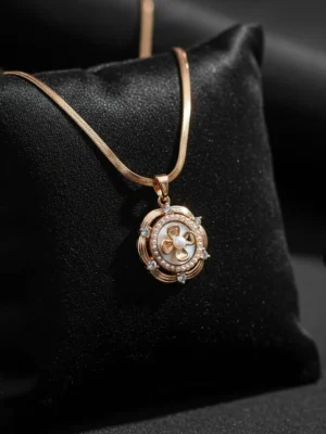 Close-up of LIVNT Petal Whorl Antitarnish Necklace on black silk background, highlighting gold tones, pearl center, and sparkling stones.