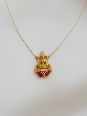 Front view of a traditional South Indian Goddess Lakshmi locket crafted in matte gold, featuring two oval ruby-toned Kemp stones, hung on a barely visible gold micro-chain against a clean white backdrop.