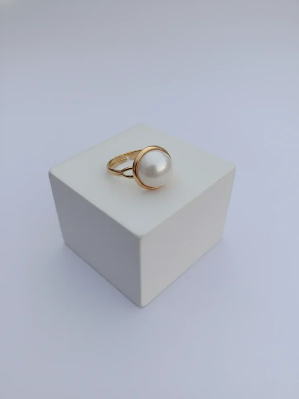 An angled, three-quarter view of the Orb Ring, showcasing the pearl's beautiful luster and the delicate structure of the gold setting on a white background.