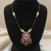 Petal Drop Invisible Necklace by LIVNT displayed on black velvet bust — elegant gold wire necklace with ruby, emerald, and crystal floral pendant for a luxurious statement look.