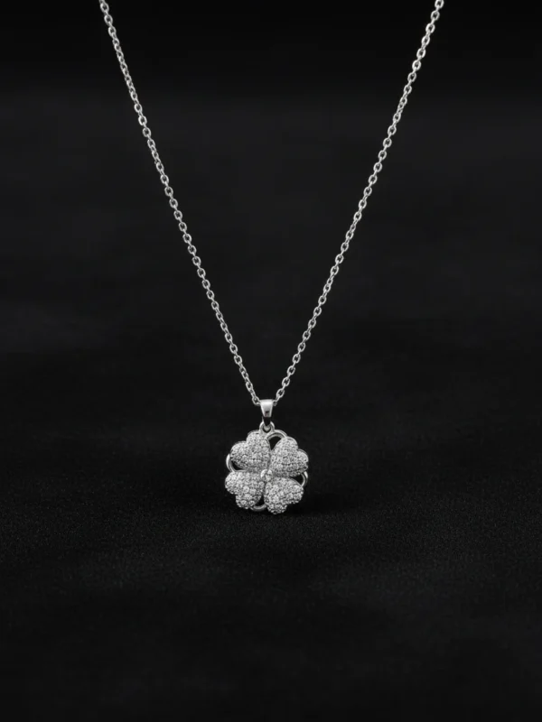 Spinning Heart Clover necklace on matte black background, low-key lighting, luxury jewelry display.