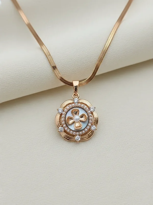 LIVNT Petal Whorl Antitarnish Necklace displayed on cream background showing fine gold detailing, pearl center, and crystal accents.