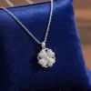 Spinning Heart Clover necklace on royal blue velvet jewelry pillow, close-up, silver pave heart pendant.