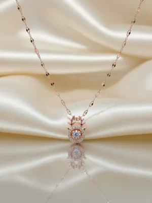 A delicate rose gold fawn necklace with a dancing diamond center stone, resting on a lustrous cream silk background reflecting its shine.