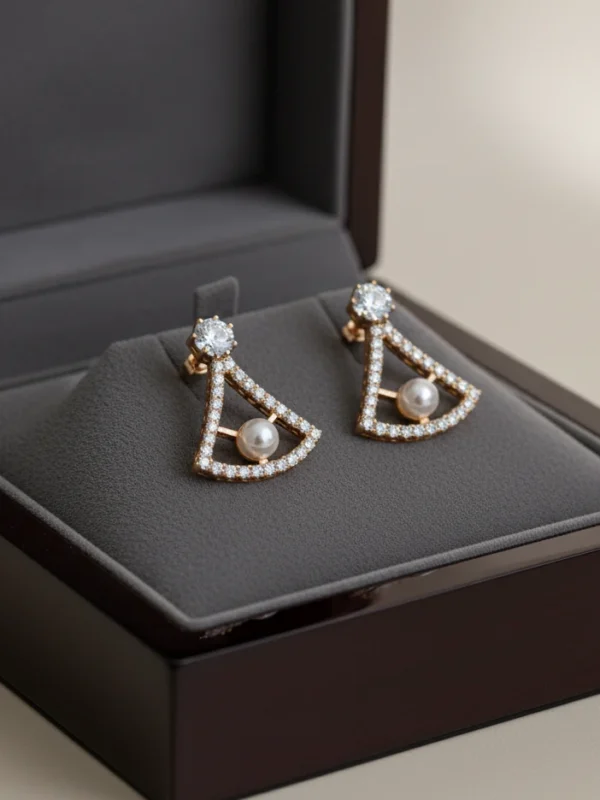 A pair of LIVNT Pearl Triangle Stud earrings displayed in an open luxury jewelry box, showcasing their exquisite detail and premium presentation.