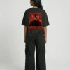 Woman wearing Akshaye Khanna Dhurandhar inspired oversized black t-shirt with rebellion back print artwork in heavyweight cotton streetwear style