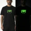 Day and night comparison of LIVNT glow-in-the-dark cat t-shirt on male model